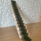 1:12 scale miniature edged stair runner carpet in green with a patterned border, shown laid on a wood staircase
