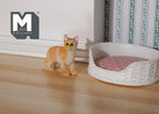 1:12 scale miniature standing orange tabby cat with white chest, shown on a wood floor beside a pet bed