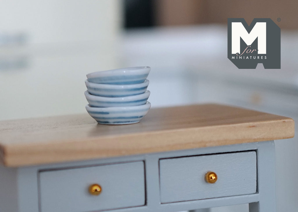 1:12 scale miniature white ceramic bowls, set of 4, shown stacked on a gray kitchen cabinet with a wood top