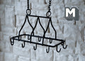 1:12 scale miniature black metal ceiling pot rack with S hooks and hanging chains, shown against a white stone wall