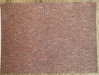 1:12 scale miniature weathered embossed brick wall sheet in red brick, full sheet shown flat with running bond pattern