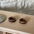 1:12 scale miniature cat food bowls in bronze brown glaze, set of 2, shown on a wood shelf beside a coin