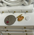 1:12 scale miniature makeup compact in gold with clasp, powder puff and embossed floral lid, open on a vanity by a coin