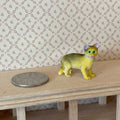 1:12 scale miniature standing tabby cat in tan with dark stripes, shown beside a coin on a wood shelf