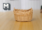 1:12 scale miniature oval woven rope basket in natural tan with a braided rim, shown on a wood table