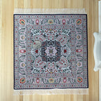1:12 scale miniature floral medallion area rug with fringe in gray and red with a navy border, shown on a wood floor