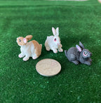 1:12 scale miniature bunny rabbit figures, set of 3, style C, tan, white and gray, shown on green grass beside a coin