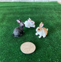 1:12 scale miniature bunny rabbit figures in gray, white and tan, set of 3, shown on green grass beside a coin for scale