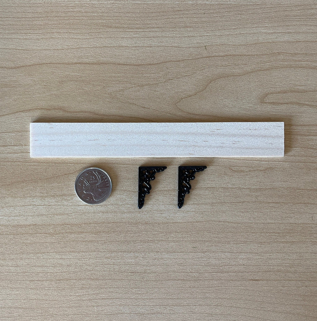 1:12 scale miniature wood wall shelf with black scroll metal brackets and nails, parts laid out beside a coin
