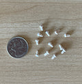 1:12 scale miniature unpainted wood mushroom door knobs, set of 12, shown scattered on a wood surface beside a coin