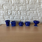 1:12 scale miniature cobalt blue glazed pottery planters in assorted shapes, set of 5, lined up by a stone wall