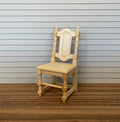 1:12 scale miniature unpainted wood dining chair with shaped back splat and turned legs, shown on a wood floor