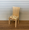 1:12 scale miniature unpainted wood slat back dining chair with a floral fabric seat pad, shown on a wood floor
