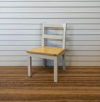 1:12 scale miniature wood ladder back dining chair in white with natural wood seat, shown on a wood floor