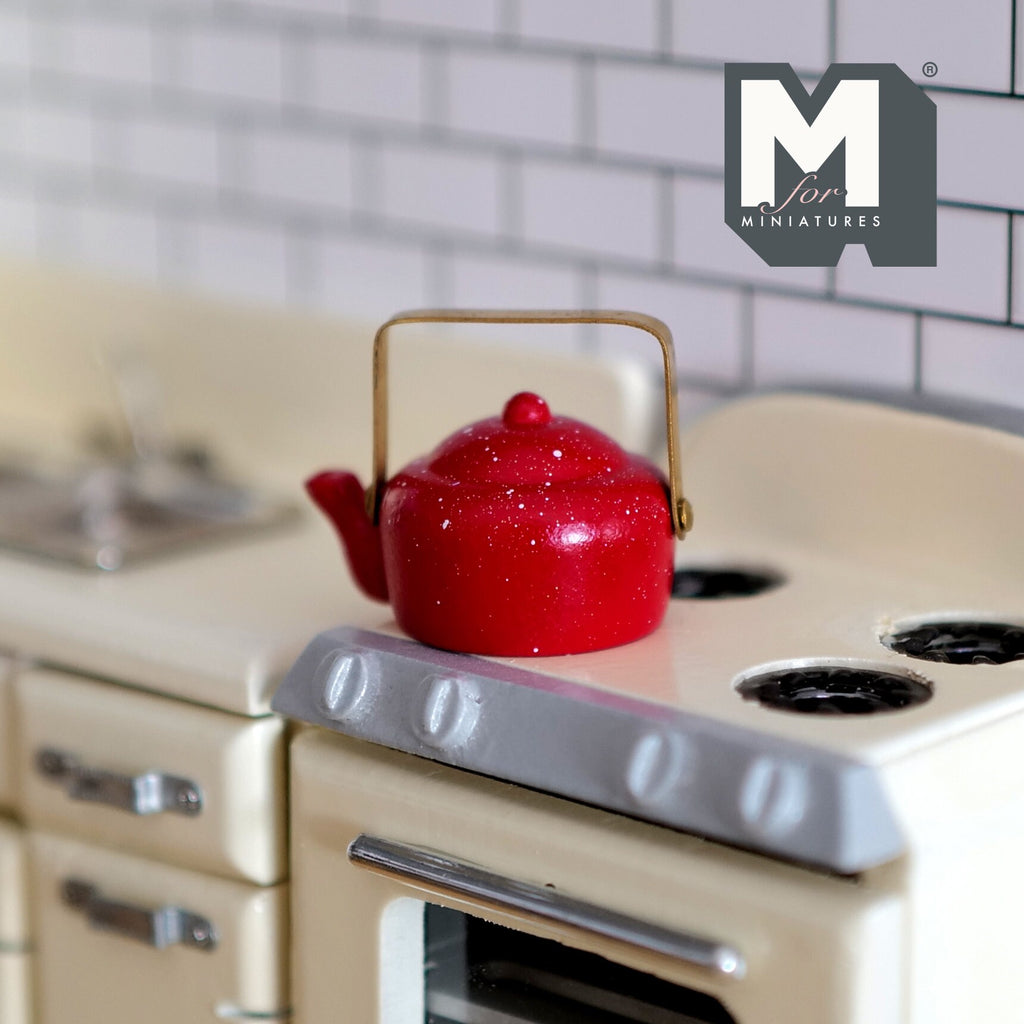 1:12 scale miniature enamel kettle in red with white speckles, gold handle and fixed lid, on a cream stove