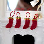 1:12 scale miniature felt Christmas stockings in red with green and gold trim, set of 4, hanging on a white fireplace mantel