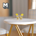 1:12 scale miniature vodka tonic drinks with lemon and straw, set of 2, shown on a round marble top table