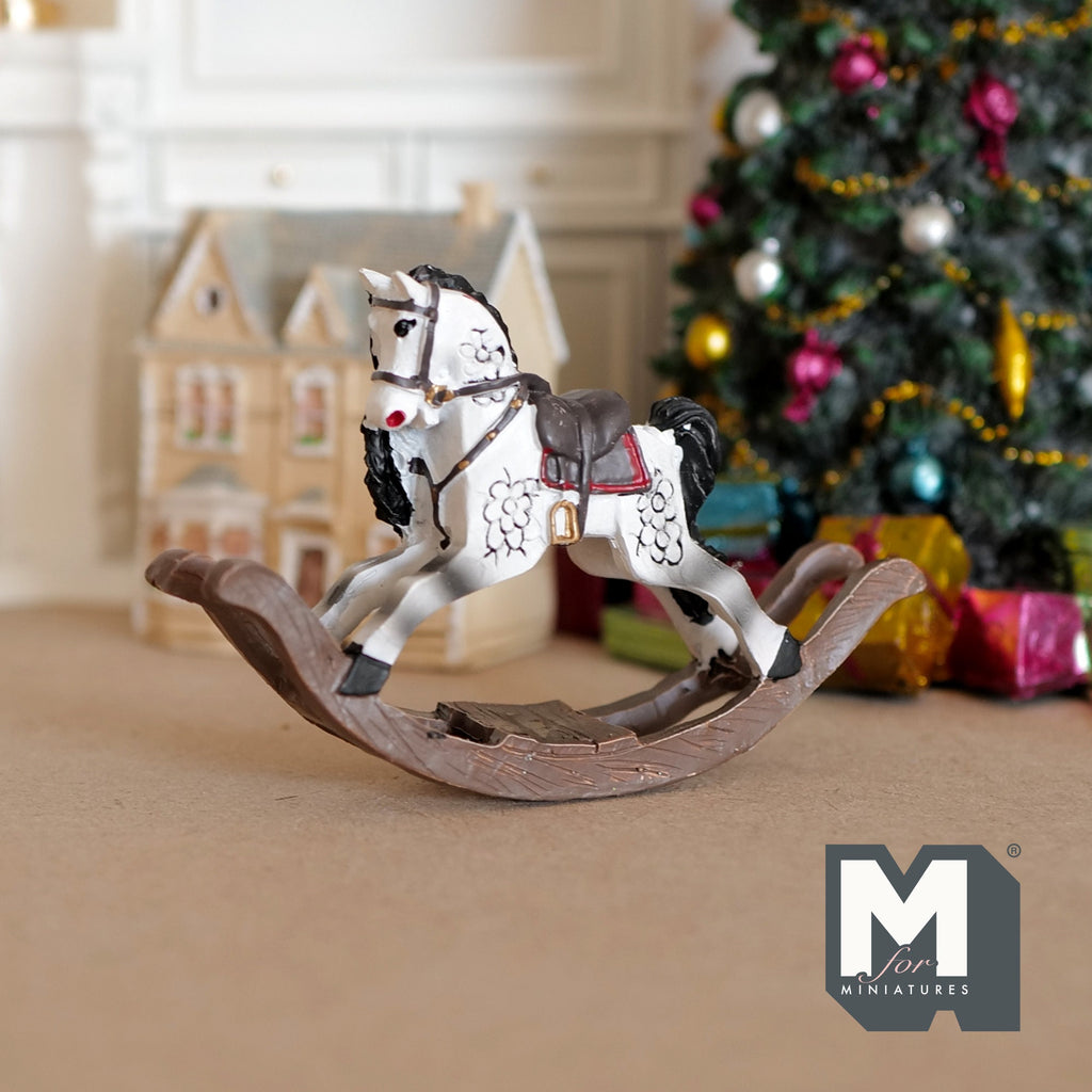 1:12 scale miniature cast resin dapple gray rocking horse with red saddle, shown in front of a Christmas tree