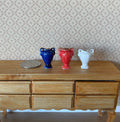 1:12 scale miniature ceramic amphora posy vases, set of 3 in blue, red and white, shown on a wood sideboard with a coin