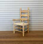1:12 scale miniature unpainted wood ladderback armchair with woven rush seat, shown against white siding