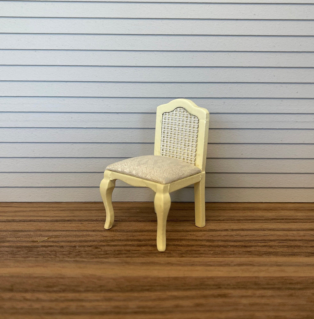 1:12 scale miniature wood French style vanity chair in cream with a cane look back and curved legs, on a wood floor