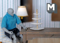 1:12 scale miniature 4 tier dessert stand in white with round tiers and gold center post, on a table by an artist figure