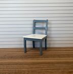 1:12 scale miniature wood ladder back dining chair in blue gray with a cream seat, shown on a wood floor