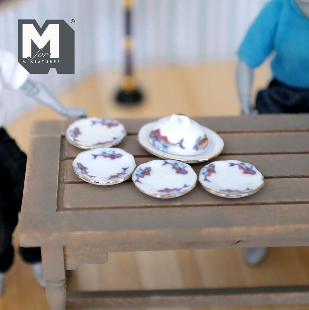 1:12 scale miniature ceramic plate set with oval platter, cover dome and purple floral rim, set of 6, on a gray table