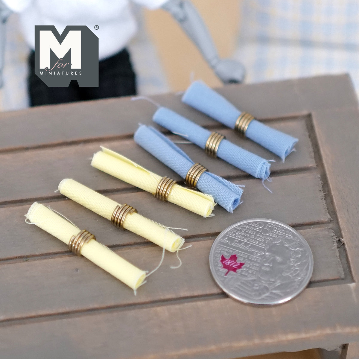 1:12 scale miniature rolled table napkins with napkin rings, set of 6, blue and yellow, shown beside a coin