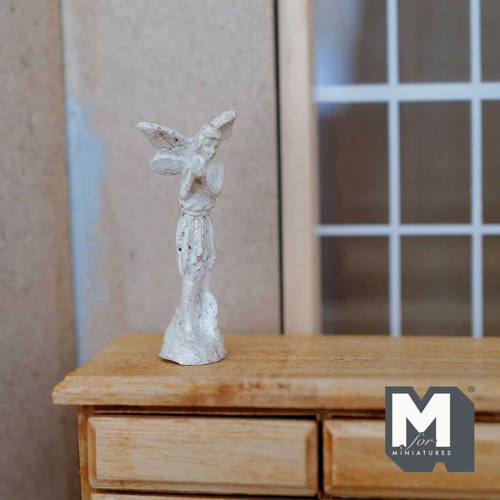 1:12 scale miniature cast resin white angel statue on a pedestal, shown on a wood dresser by a window