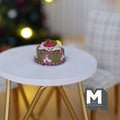 1:12 scale miniature Christmas chestnut cake with chocolate sides, holly and cream topping, non edible, on a white table