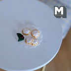 1:12 scale miniature cream topped pies on a clear plate with a holly garnish, shown on a round white table