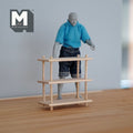 1:12 scale miniature unpainted wood open bookstand with 3 tiers and corner posts, shown with a figure for scale