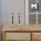 1:12 scale miniature metal candlesticks with square bases in silver, set of 2, shown on a wood dresser