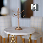 1:12 scale miniature mug tree in bronze with 6 hooks and round base, shown on a round marble top table