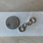 1:12 scale miniature metal handcuffs with chain link in silver tone, non working, shown beside a coin for scale