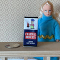 1:12 scale miniature charcoal briquets bag with printed label in black, red and white, shown beside a figure and a coin