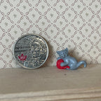 1:12 scale miniature gray kitten playing with a red yarn ball, shown beside a coin for scale