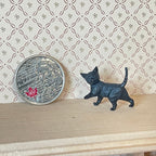 1:12 scale miniature walking kitten figure in black with raised tail, shown beside a coin for scale
