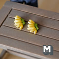1:12 scale miniature banana bunches, set of 2, yellow bananas with green stems, shown on a gray wood table