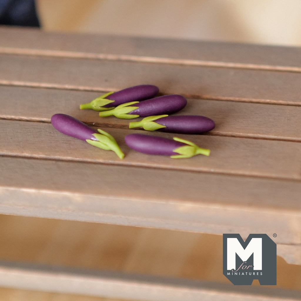 1:12 scale miniature eggplants in dark purple with green stems, set of 5, shown on a wood slat table
