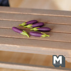 1:12 scale miniature eggplants in dark purple with green stems, set of 5, shown on a wood slat table