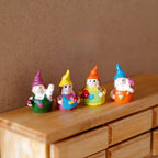 1:12 scale miniature garden gnomes in multicolor with pointed hats, set of 4, shown lined up on a wood dresser