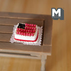 1:12 scale miniature clay American flag strawberry cake with blueberries and cream stripes, shown on a wood table