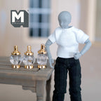 1:6 scale miniature pump dispenser bottles in clear and gold, set of 3, faceted round bodies, shown beside a poseable figure