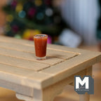 1:12 scale miniature iced chocolate in a tall clear glass, shown on a light wood slat table