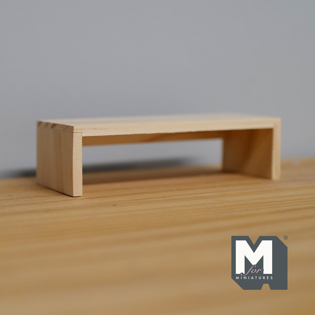 1:12 scale miniature unpainted wood low table with slab ends, simple bench shape, shown on a wood surface