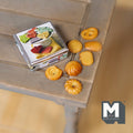1:12 scale miniature butter cookie tin with 7 loose cookies, printed lid, shown on a rustic wood table