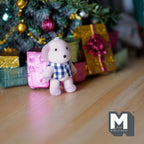 1:12 scale miniature puppy in blue plaid shirt with flocked skin, shown with wrapped gifts under a Christmas tree