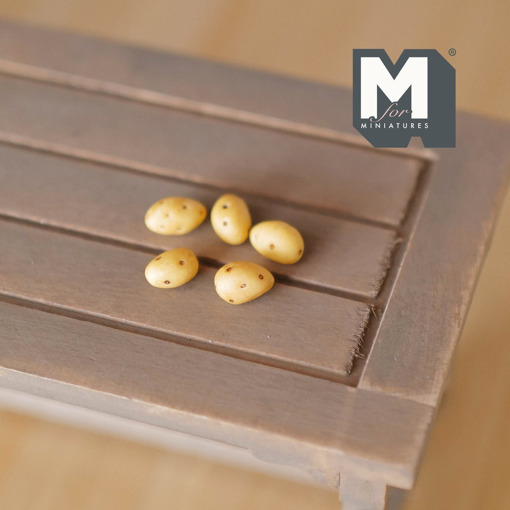 1:12 scale miniature potatoes with speckled yellow skins, set of 5, shown on a gray wood table